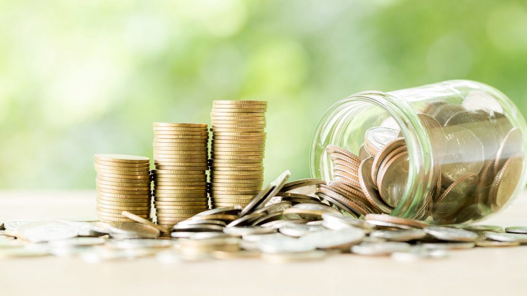 Coin on wooden table in front of green bokeh background. coins a concept of investment and saving moneys.
